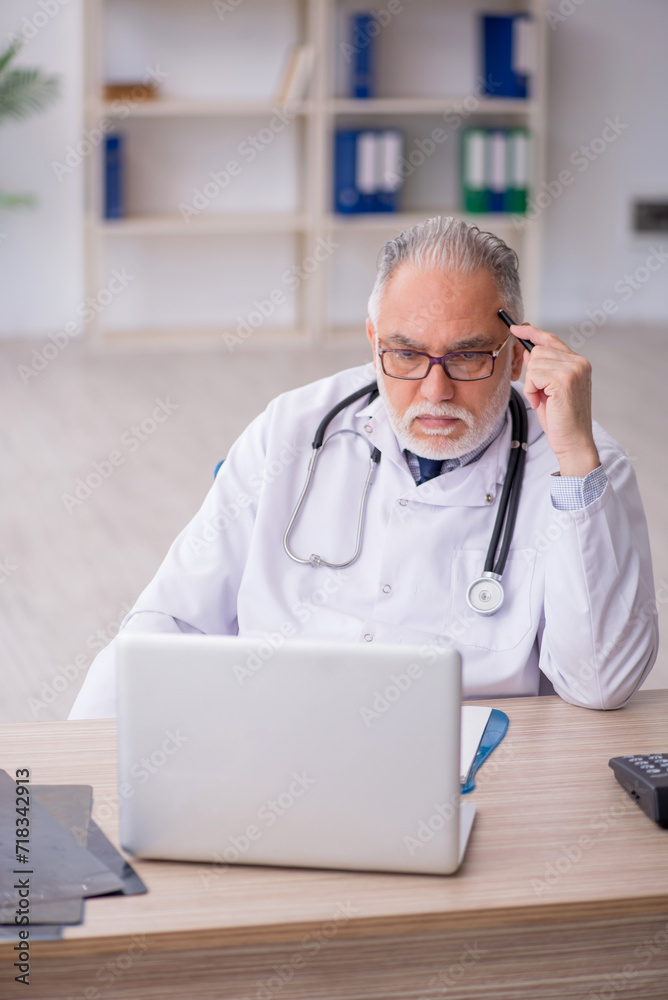 Old male doctor in telemedicine concept Old male doctor in telemedicine concept