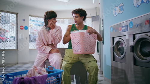 Obraz na płótnie Teenage couple talking together in public laundromat