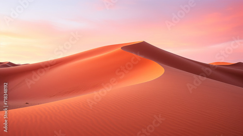 A striking photograph of a desert landscape at dusk  featuring towering sand dunes bathed in the warm hues of the setting sun  against a vibrant orange and pink sky