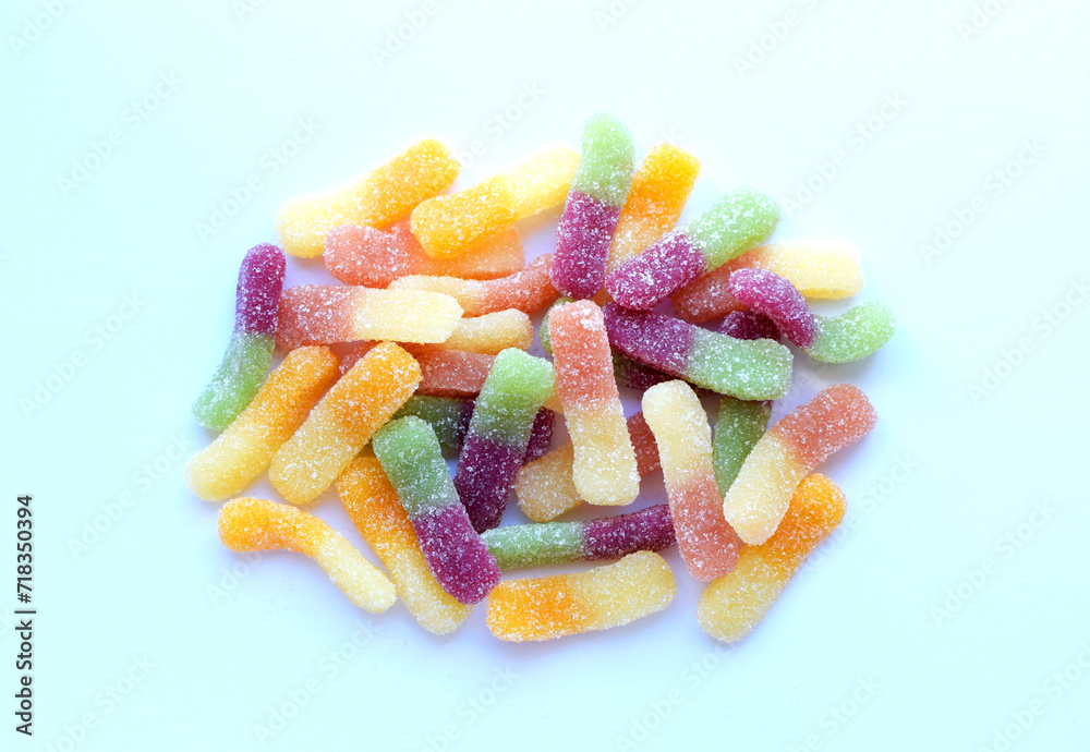 Multi-colored sour gummy worms on a light background