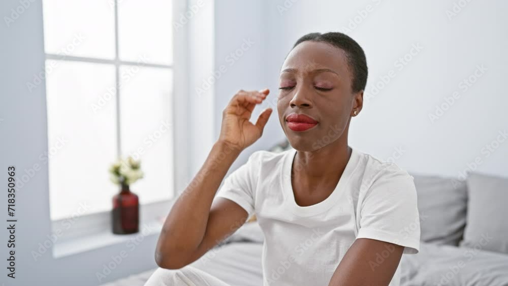 Smiling african american woman lying on bed in a cozy bedroom, pointing to her head with a finger, got a great idea or a feel-good memory! Smiling african american woman lying on bed in a cozy bedroom, pointing to her head with a finger, got a great idea or a feel-good memory!