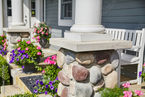 Sunny Residential Entrance with Stone Column and Flower Arrangements