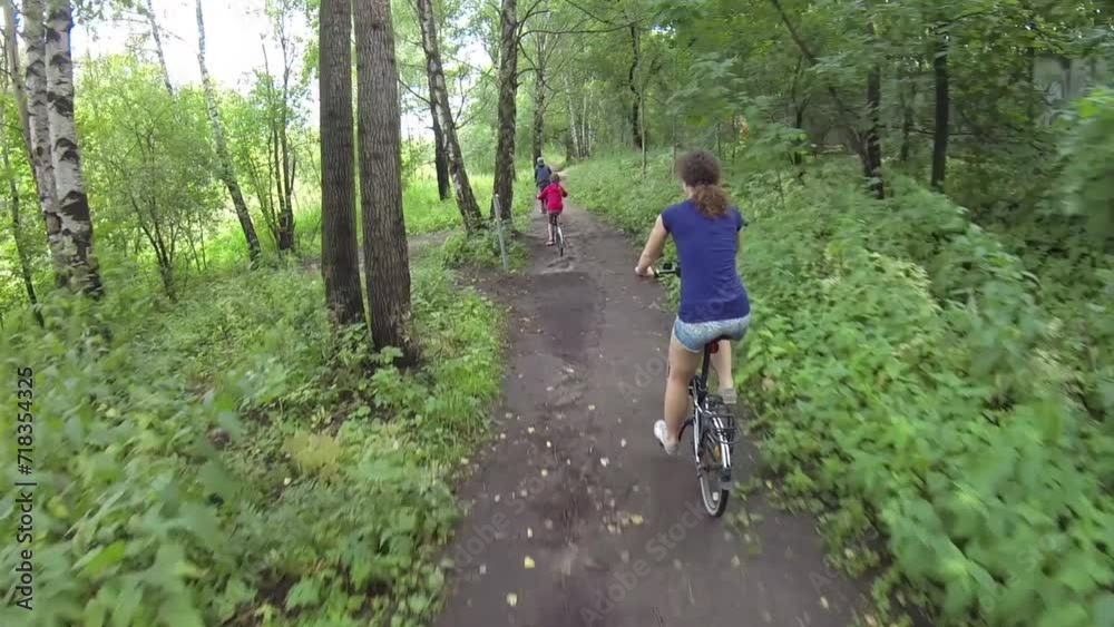 Woman, girl and boy mr ride bicycles in park Woman, girl and boy mr ride bicycles in park