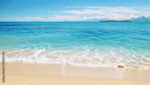 sandy beach with a blue ocean in the background  light green hue water with small white waves