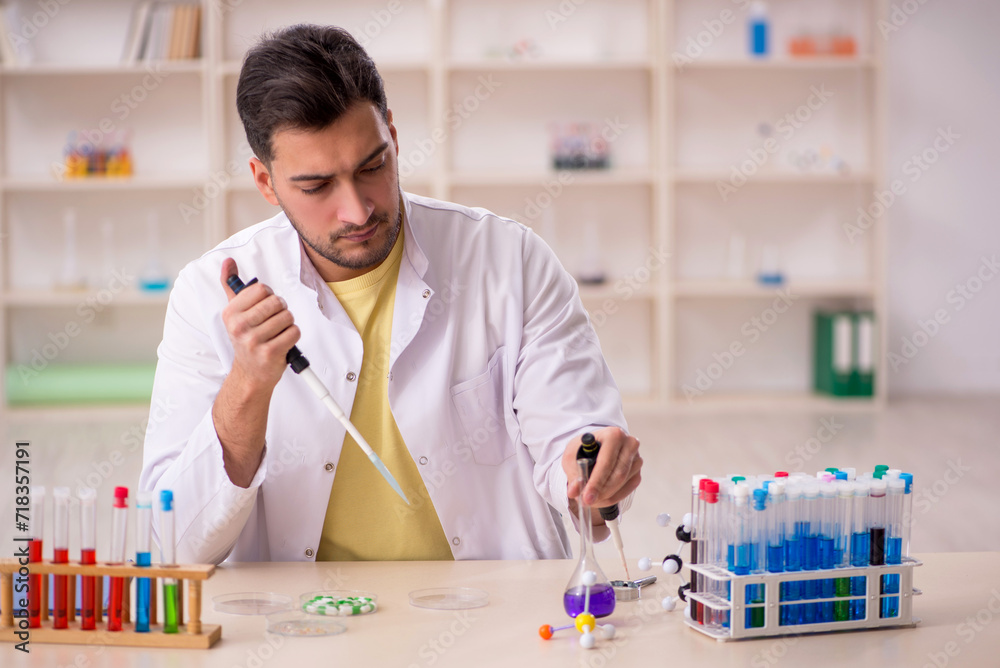 Young male chemist sitting at the lab Young male chemist sitting at the lab