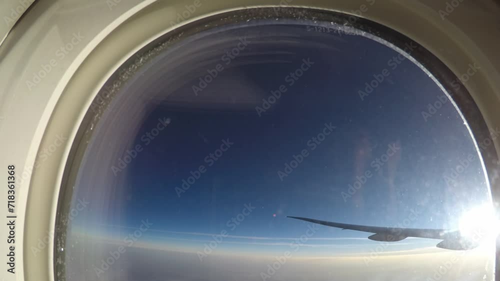 The plane flies over clouds, wing with ailerons, view from illuminator The plane flies over clouds, wing with ailerons, view from illuminator