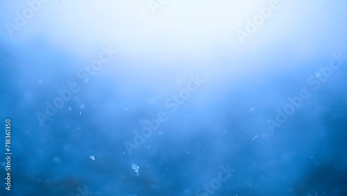Blue snowfall background effect. Abstract dynamic energy background. Shallow depth of field with soft focus.