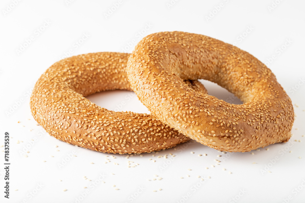 Two traditional turkish simit bagels with sesame seeds closeup on white Two traditional turkish simit bagels with sesame seeds closeup on white