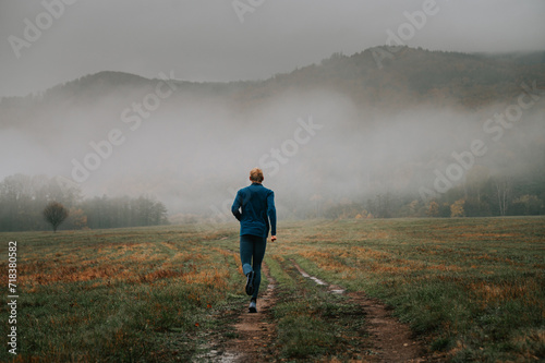 A Young Trail Runner Immersed in the Mysterious Grey Hues of Autumn © kovop58