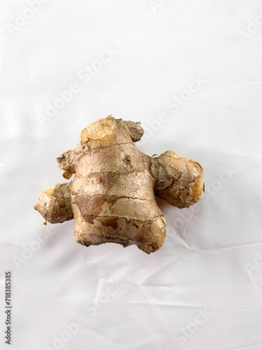 Fresh Asian ginger rhizome isolated on a white cotton cloth background.