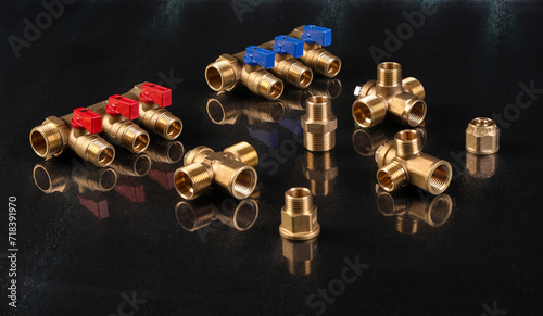 A set of metal and copper water pipe parts, a water wrench and pipe elbows, blue and red colors, black background, different shapes and different sizes