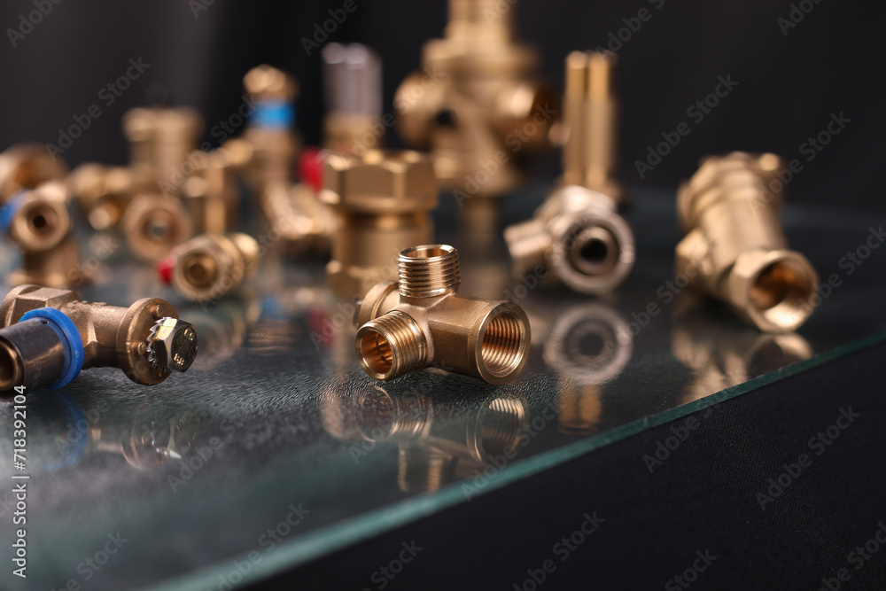 A set of metal and copper water pipe parts, a water wrench and pipe elbows, blue and red colors, black background, different shapes and different sizes A set of metal and copper water pipe parts, a water wrench and pipe elbows, blue and red colors, black background, different shapes and different sizes