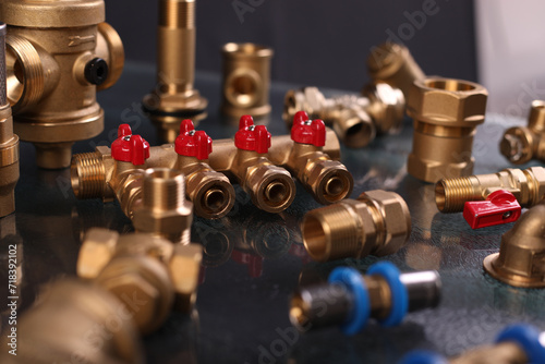 A set of metal and copper water pipe parts, a water wrench and pipe elbows, blue and red colors, black background, different shapes and different sizes