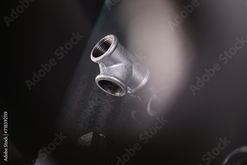 A set of metal and copper water pipe parts, a water wrench and pipe elbows, blue and red colors, black background, different shapes and different sizes