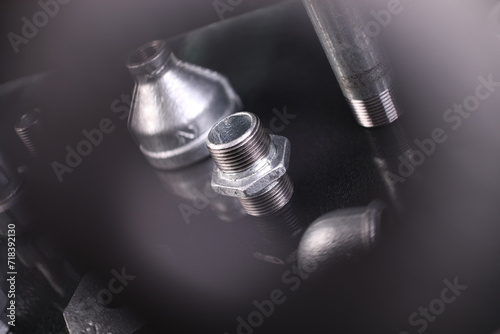 A set of metal and copper water pipe parts, a water wrench and pipe elbows, blue and red colors, black background, different shapes and different sizes