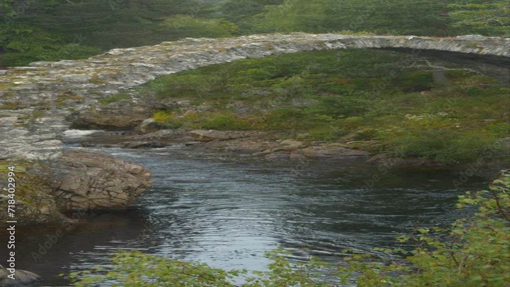 Vidéo Stock VERTICAL Old arched Coffin Bridge connecting rocky banks
