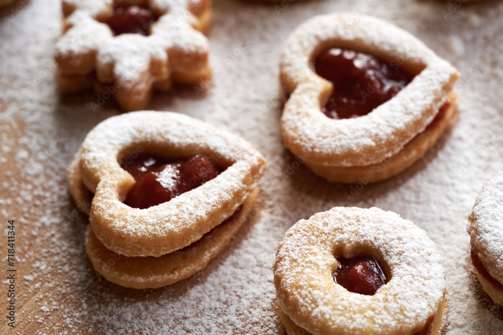 Heart shaped Linzer Christmas cookies filled with strawberry marmalade and dusted with sugar