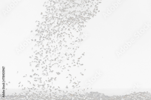 Black Sesame seeds flying explosion, black grain wave floating. Abstract cloud fly splash in air. Sesame seed is material food. Black background Isolated selective focus blur