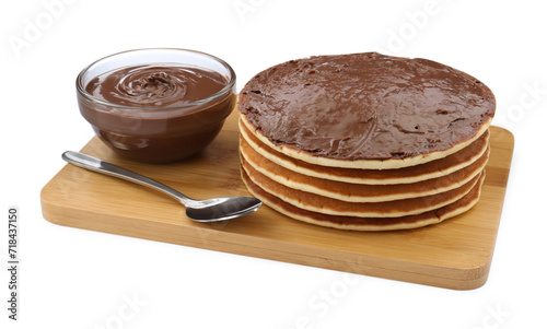 Tasty pancakes with chocolate paste and spoon isolated on white