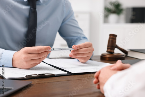 Lawyers working with documents at wooden table in office, closeup