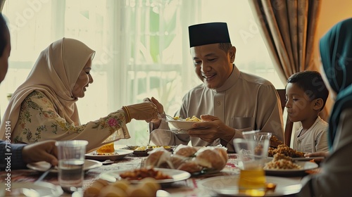 Portrait of moslem family having dinner in dining room, discussing while eating in happy. Moslem family is having break fasting on Ramadan. photo