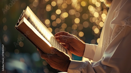 Image of man hands reading Al Quran on light bokeh background. Muslim man reading Koran in Ramadan. photo
