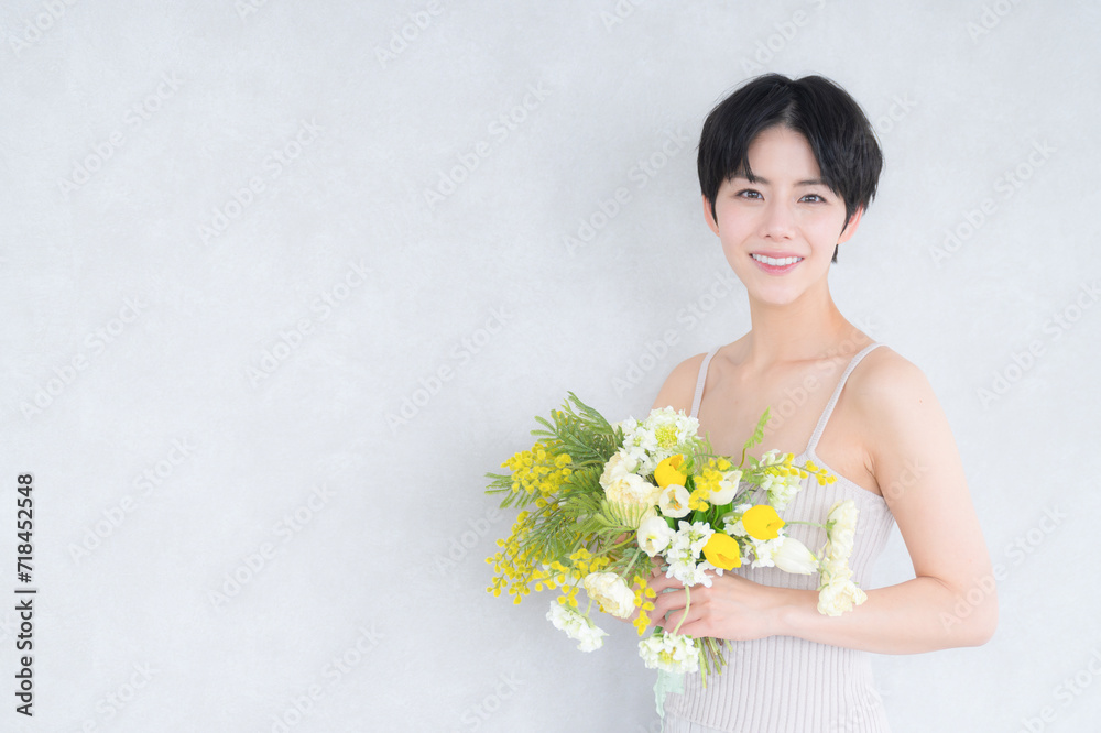 Cute spring beauty image Mimosa and cute Asian (Japanese) woman looking at camera Cute spring beauty image Mimosa and cute Asian (Japanese) woman looking at camera