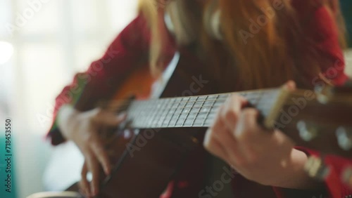 Girl playing acoustic guitar and singing song. Female guitarist playing musical instrument photo