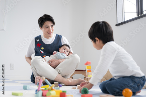 保育園などで遊ぶ幼児と男子保育士と赤ちゃんのイメージ photo