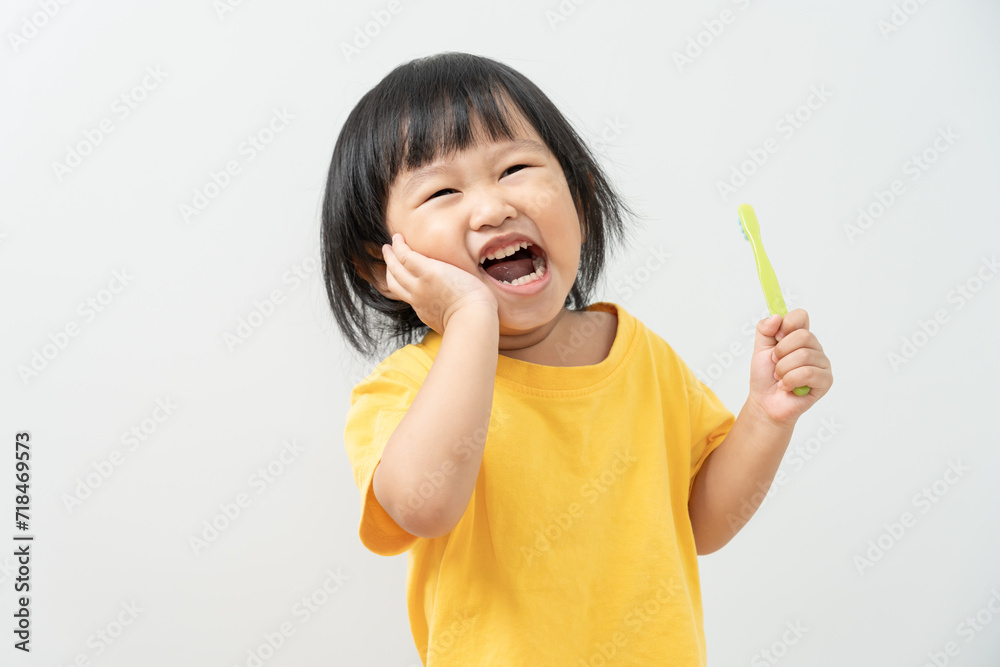 little asian girl presses hand to cheek, suffers from pain in tooth. Teeth decay, dental problems, child emotions and facial expression, oral health care, reducing sweets, fluorine coating little asian girl presses hand to cheek, suffers from pain in tooth. Teeth decay, dental problems, child emotions and facial expression, oral health care, reducing sweets, fluorine coating