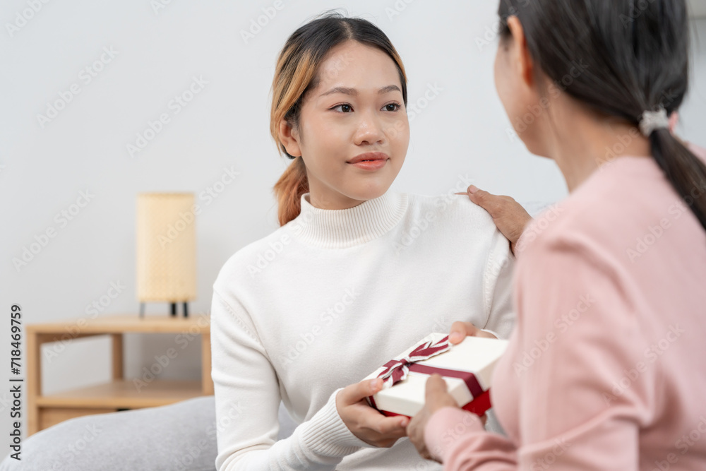 Mother day, cute asian teen girl give gift box to mature middle age mum. Love, kiss, care, happy smile enjoy family time. celebrating special occasion, happy birthday, happy new years, merry Christmas Mother day, cute asian teen girl give gift box to mature middle age mum. Love, kiss, care, happy smile enjoy family time. celebrating special occasion, happy birthday, happy new years, merry Christmas