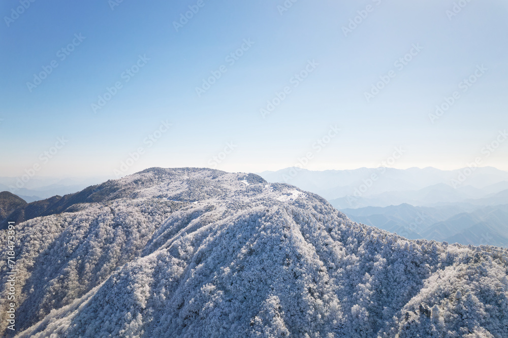 Beautiful aerial view of snow covered pine forests. Rime ice and hoar frost covering trees. Scenic winter landscape of Baizhangling, Lin'an, Hangzhou, Zhejiang, China. Drone landscape in winter.