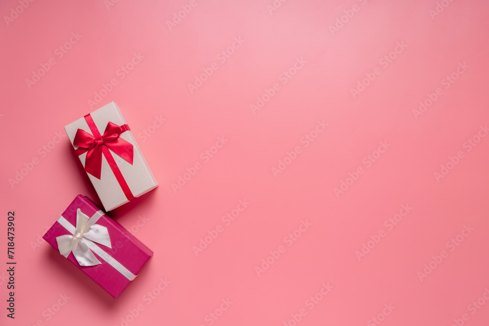 Top view photo of valentine's day decorations giftbox with silk ribbon bow on isolated pastel pink background with copyspace, concept Valentine's Day. Top view photo of valentine's day decorations giftbox with silk ribbon bow on isolated pastel pink background with copyspace, concept Valentine's Day.