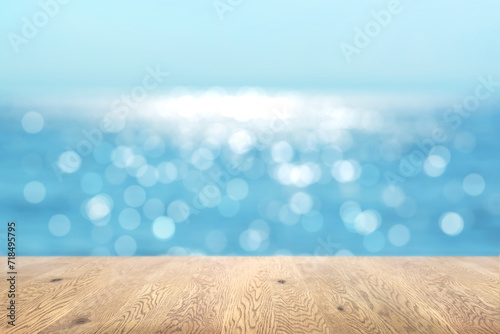 木目のある木製のテーブル越しに見えるボケた背景、奥行きのある背景、海の背景画像