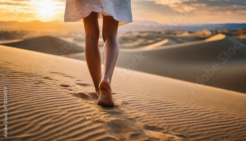 Woman's bare feet grace desert sands at sunset, embodying wanderlust and the warmth of summer exploration