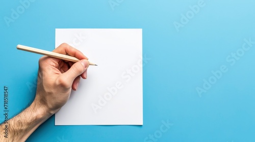 Top view of hands holding pencil and white paper