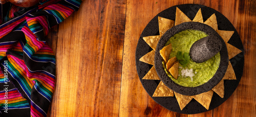 Guacamole. Avocado dip with tortilla chips also called Nachos served in a bowl made with volcanic stone mortar and pestle known as molcajete. Mexican easy homemade sauce recipe very popular.