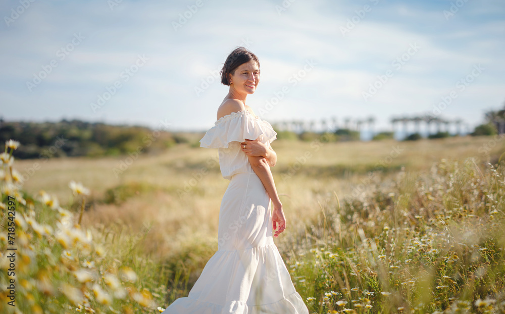 Beautiful Asian young woman in white dress outdoor in flower field. embracing fresh air and engaging in outdoor activities. Friluftsliv concept means spending as much time outdoors as possible