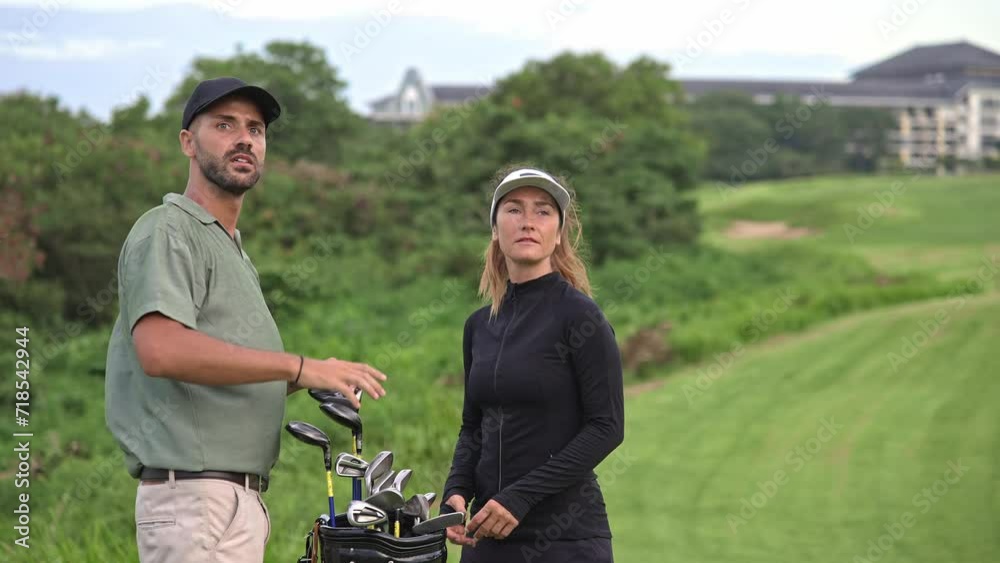 Sports Man and Athletic Woman at Golf Course with Clubs and Balls in Bag. Couple of Two Caucasian People Looking at Game Playing with Putter. Modern Concept of Professional Male and Training Female Sports Man and Athletic Woman at Golf Course with Clubs and Balls in Bag. Couple of Two Caucasian People Looking at Game Playing with Putter. Modern Concept of Professional Male and Training Female