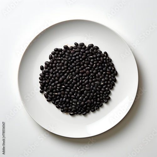 Black beans on a plate isolated on white background. Top view.