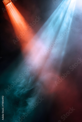 Colorful stage lights with smoke and rays of light on black background