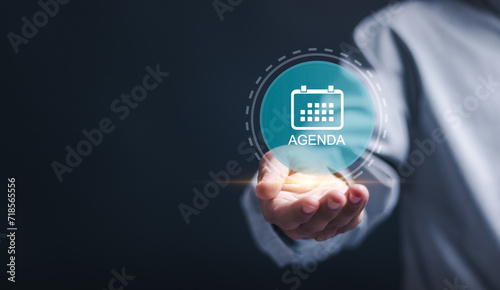 Agenda meeting appointment activity information concept. Businessman holding virtual Agenda icon for agenda meeting plan schedule in personal organizer. photo