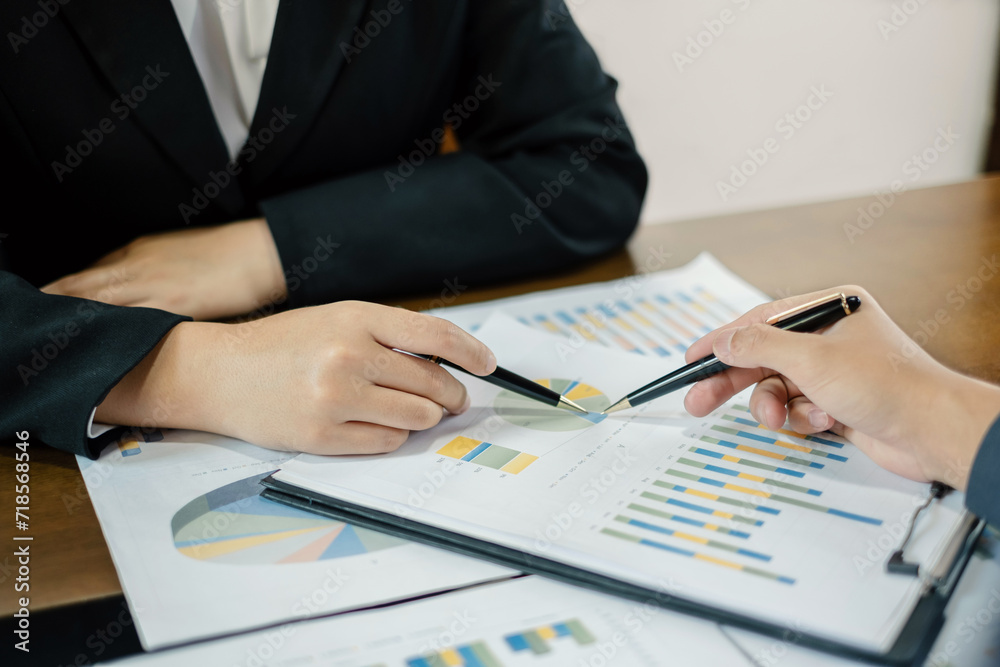 Two business leaders talk about charts, financial graphs showing results are analyzing and calculating planning strategies, business success building processes Two business leaders talk about charts, financial graphs showing results are analyzing and calculating planning strategies, business success building processes