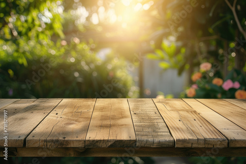  A wooden table with no objects on it and a blurred outdoor garden background. The wooden table provides space for text and can be used for marketing promotions