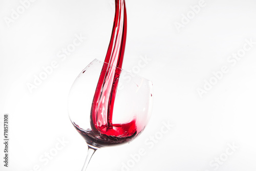 Photograph of red wine being poured into a wine glass