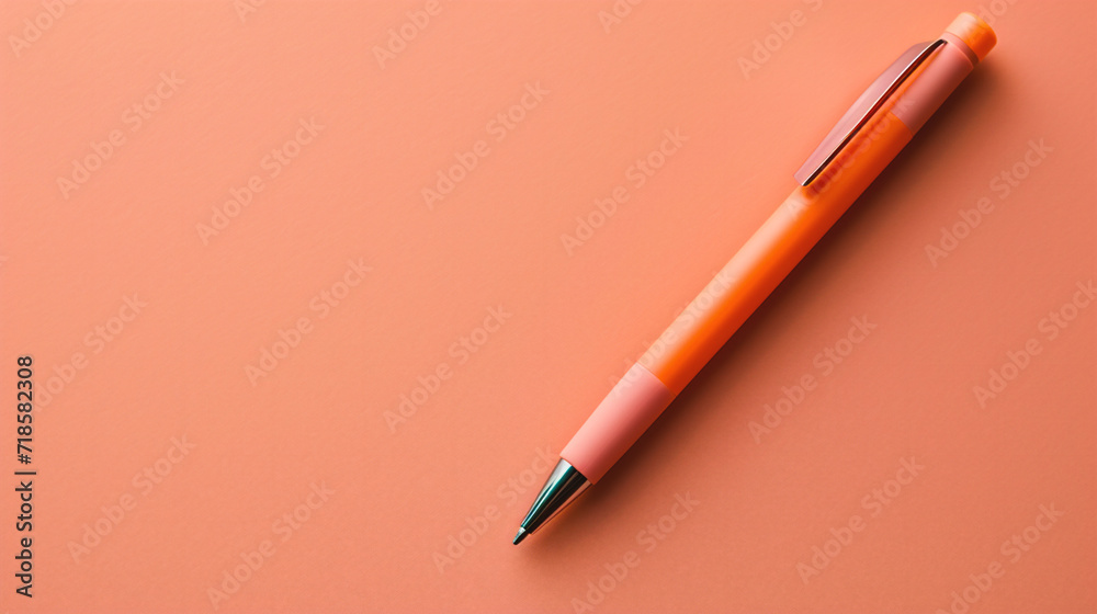 Orange pen on a pink background. Top view. Copy space. Orange pen on a pink background. Top view. Copy space.