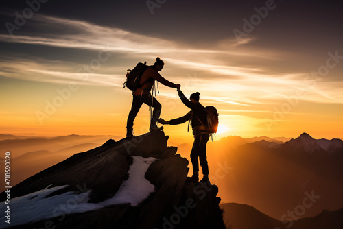Silhouette of Two Climbers Helping Each Other on Mountain Peak at Sunrise. Adventure and Teamwork Concept