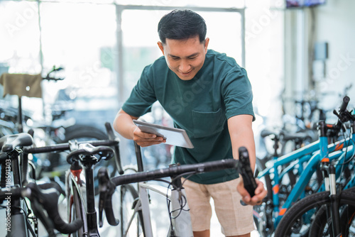young man using a pad while trying out a bicycle grip handle at a bicycle shop
