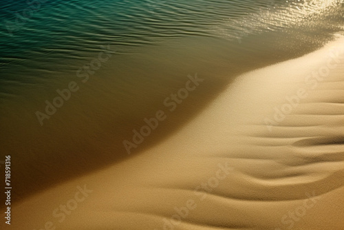 Landscape and nature concept. Abstract and surreal landscape view of golden sand dunes and blue water. Top aerial view, minimalist style background with copy space