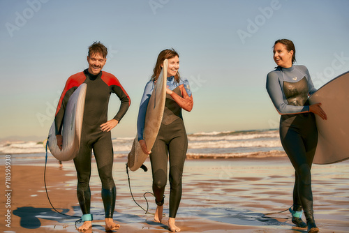 Photography Group of surfers with surfboards in wetsuit are walking on the beach after ride